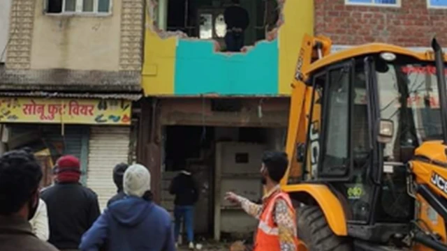 मकान तोड़ता बुल्डोज़र