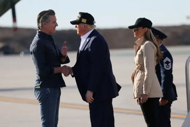 山火事の被害状況を視察するため、24日にロサンゼルス国際空港に到着したトランプ大統領と握手を交わすカリフォルニア州のギャヴィン・ニューサム知事（左）