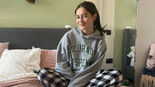 침대 위에 앉아 카메라를 응시하는 제스 가빈