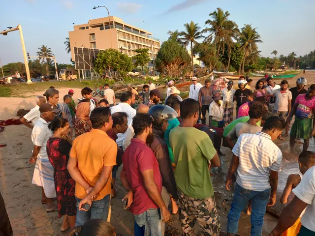 දැල කෙමෙන් කෙමෙන් ගොඩබිමට ලංවෙද්දි ජනතාව වෙරළට ඒකරාශී වෙති. 