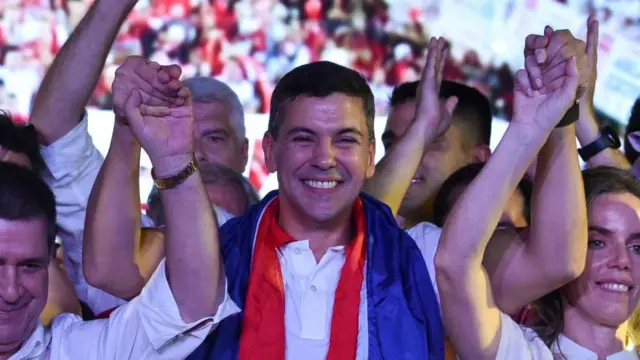 Santiago Peña, do Partido Colorado, comemora comesposa, Leticia OcamposPea e o ex-presidente paraguaio Horacio Cartes, após vencer a eleição presidencialAssunção30abril