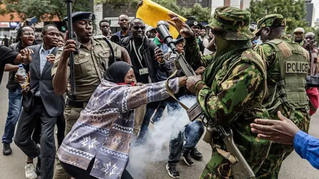በተቃውሞው ላይ አንዲት ሴት ፖሊሶችን ስትከላከል