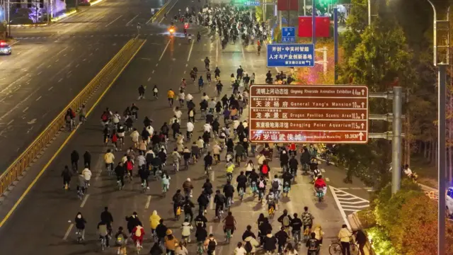 College students from Zhengzhou cycle to Kaifeng, 50 km away, at night on November 9, 2024 in Kaifeng, Henan Province of China.