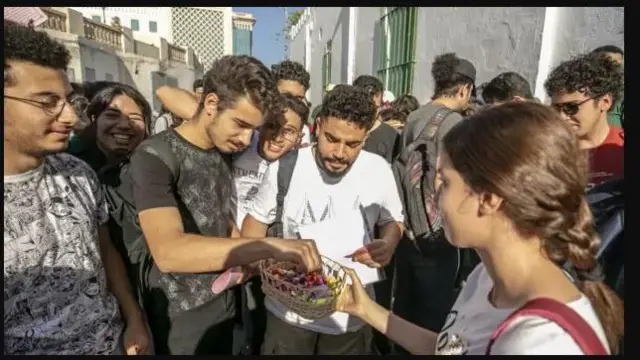 Akẹkọọ kan ree to n pin suwiiti fun awọn akẹgbẹ rẹ saaju ko to wọ inu iyara ikẹkọọ wọn ni ibi ti wọn ti n lọ se idanwo lorileede Tunisia