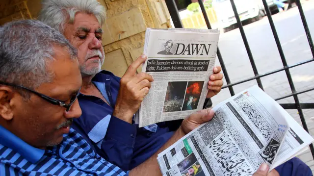 पाकिस्तानभित्र भारतीय क्षेप्यास्त्र हमलाबारे प्रकाशित समाचार पढ्दै कराचीमा मानिसहरू