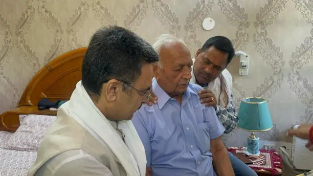 Photo of Hawa Singh Narwal (centre) grieving the loss of his grandson Vinay Narwal