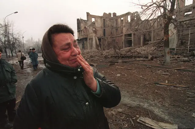 Жительница Грозного у руин здания