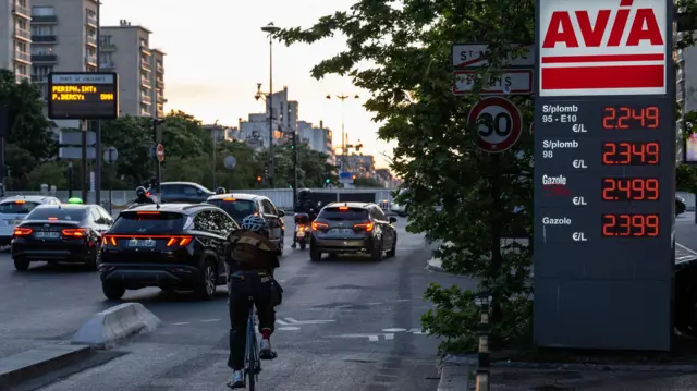 يمر راكب دراجة هوائية أمام لوحة أسعار الوقود في محطة وقود في سان ماند، شرق باريس، في 24 أبريل/نيسان 2026.