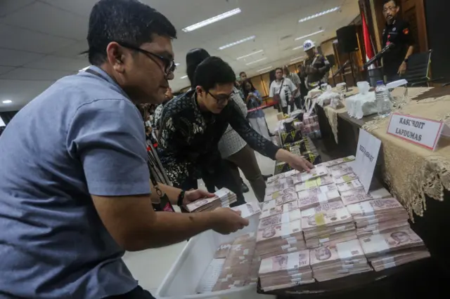 Petugas menata barang bukti terkait penangkapan mantan pejabat Mahkamah Agung Zarof Ricar di Kejaksaan Agung, Jakarta, Jumat (25/10/2024).