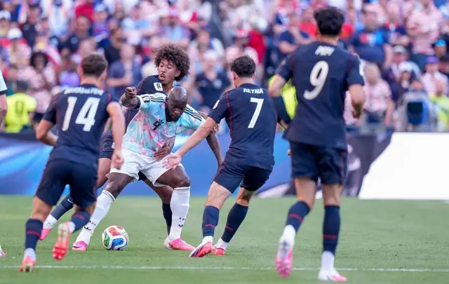 El jugador belga Romelu Lukaku entre varios jugadores de Estados Unidos. 