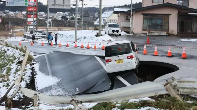Carro preso em estrada que desabou