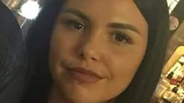 Close do rosto de Alice Webb, uma jovem de cabelos longos e escuros