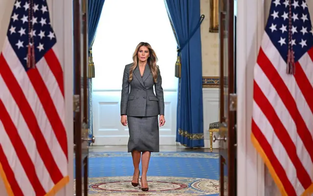 Melania Trump koridorda yürüyor.