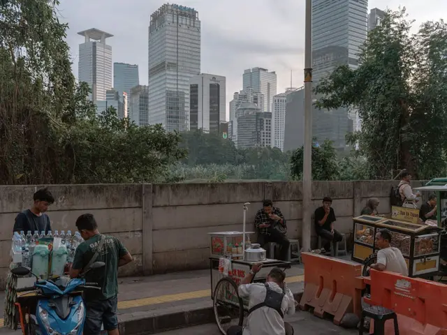 Sejumlah pedagang berjualan dengan latar gedung pencakar langit Jakarta