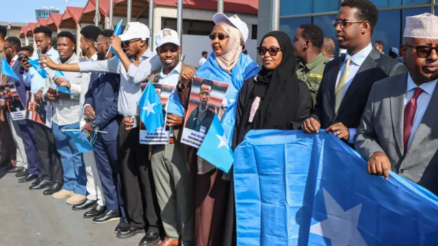 Hakem Omar Artan'ı karşılamak için, havaalanında ellerinde Somali bayrakları tutan onlarca kişi.