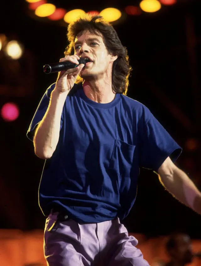 Mick Jagger cantando en Live Aid con una camiseta de Gap sencilla color azul oscuro