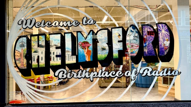 Las letras muestran la frase "Bienvenidos a Chelmsford, cuna de la radio". La palabra "Chelmsford" tiene diferentes escenas de la ciudad dentro de cada letra.