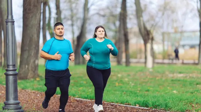 Personas con sobrepeso corriendo en el parque 