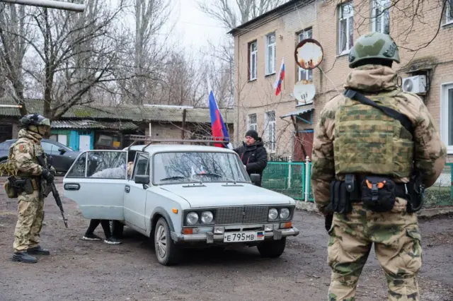 Вооруженные люди в камуфляже около автомашины с мирными жителями