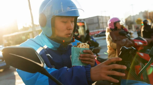 Un homme en scooter manque un hamberger