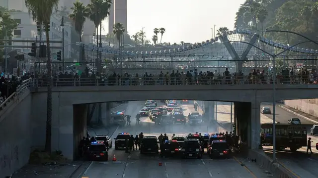 Люди на мосту, под ним - полицейские машины