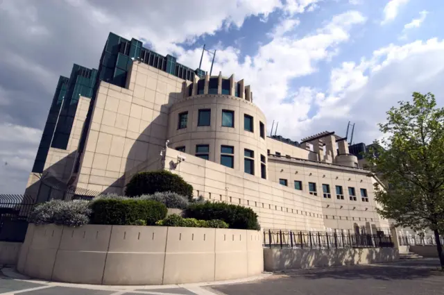 Prédio grande de concreto com janelas verdes e grades