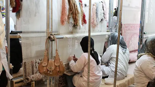 زنان مشغول فرش بافی در یک کارگاه در اصفهان