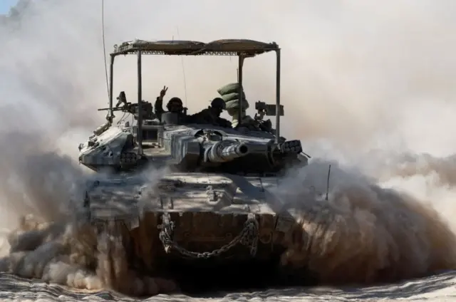 دبابة يظهر على متنها جنود إسرائيليون وتثير غباراً حولها