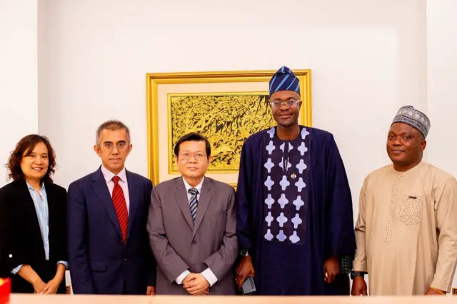 Ọgbẹni Adeniyi ya fọto pẹlu awọn aṣoju ijọba ilẹ okeere kan ni ọfiisi rẹ niluu Abuja.