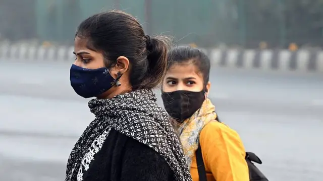 Jóvenes en Delhi yendo al trabajo con máscaras