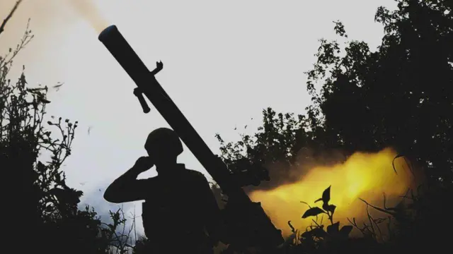 A Ukrainian soldier uses a grenade launcher in the direction of Avdiivka at the frontline in Donbas