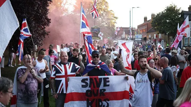 Protesters calling for di closure of di Bell Hotel gather outside di council offices in Epping on 8 August 2025.