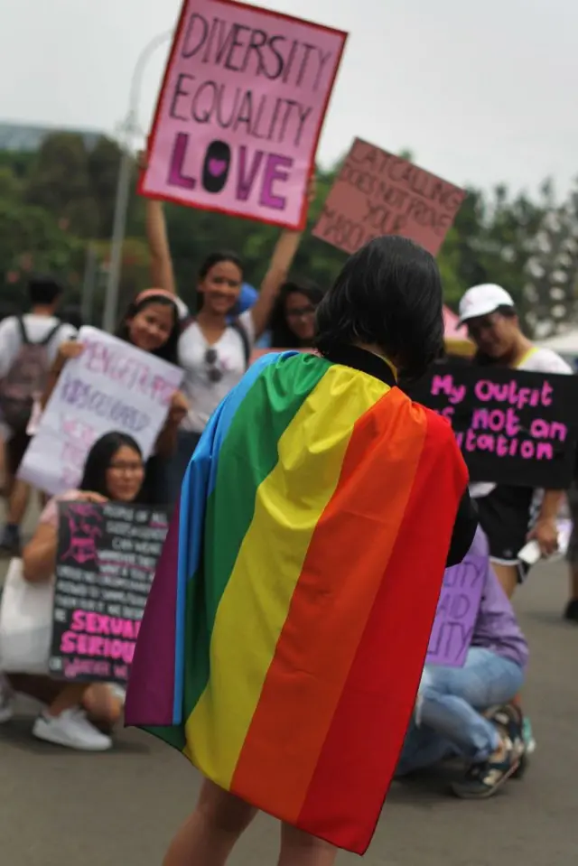Seorang perempuan mengenakan bendera pelangi pada rapat umum hari perempuan di Jakarta, pada 4 Maret 2017, sebagai bagian dari perayaan Hari Perempuan Internasional 8 Maret.