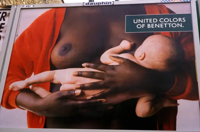 Valla de mujer negra con niño blanco en brazos