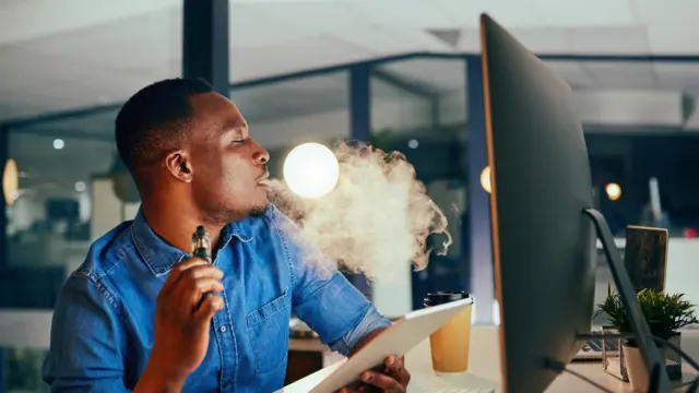 Ọkunrin to n mu siga niwaju ẹrọ ayarabiiaṣa