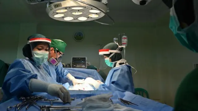 Foto yang diambil pada 10 Mei 2020 ini memperlihatkan perawat membantu dokter spesialis kandungan dan ginekologi saat melahirkan prosedur caesar di sebuah klinik bersalin di Jakarta.