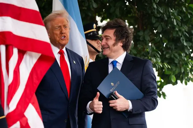 Donald Trump y Javier Milei entre banderas de Estados Unidos y Argentina durante una reunión en Washington
