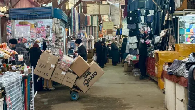 Bozorda arava tortayotgan odam.