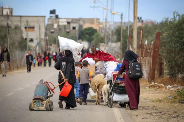 Una familia palestina camina con sus pertenencias