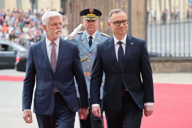 Zdjęcie przedstawiające prezydentów Polski i Czech idących po czerwonym dywanie