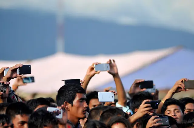 मोबाइल फोनबाट फोटो खिच्दै