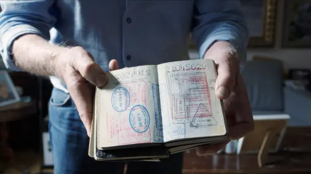 Mężczyzna trzymający otwarte paszporty