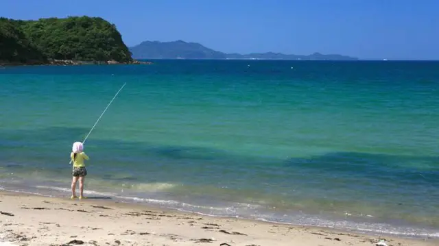 Mulher pescando na praiapixpokerFukutsu