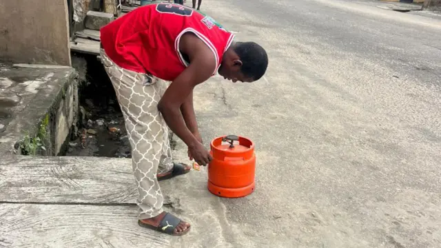 Ọkùnrin kan tó wọ aṣọ pupa bẹ̀rẹ̀ síwájú afẹ́fẹ́ gáàsì ìdáná