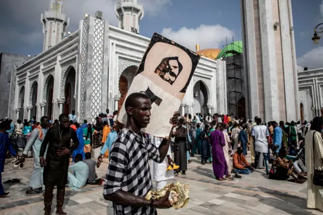 Un fidèle tenant un portrait de Cheikh Ahmadou Bamba