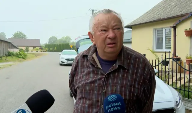 Похилого віку чоловік на тлі приватних будинків