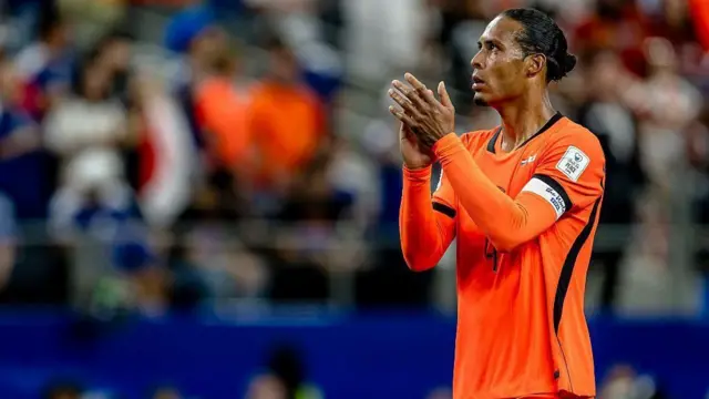 يظهر فيرجيل فان ديك، مرتدياً الزي البرتقالي الشهير لمنتخب هولندا، وهو يصفق للجماهير خلال مباراة هولندا واليابان في كأس العالم 2026 في دالاس بالولايات المتحدة، في 14 يونيو/حزيران عام 2026.