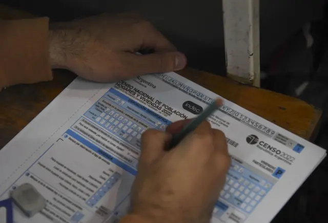 Close up of a person filling in the Argentina census questionnaire with a pencil. 1302