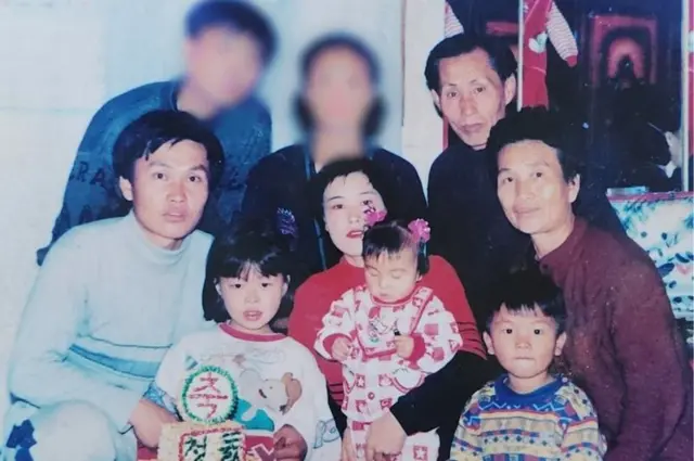 Songmi com seus pais e outros membros da família quando criança