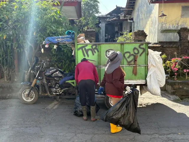 Petugas pembersih mengumpulkan sampah di Bali.